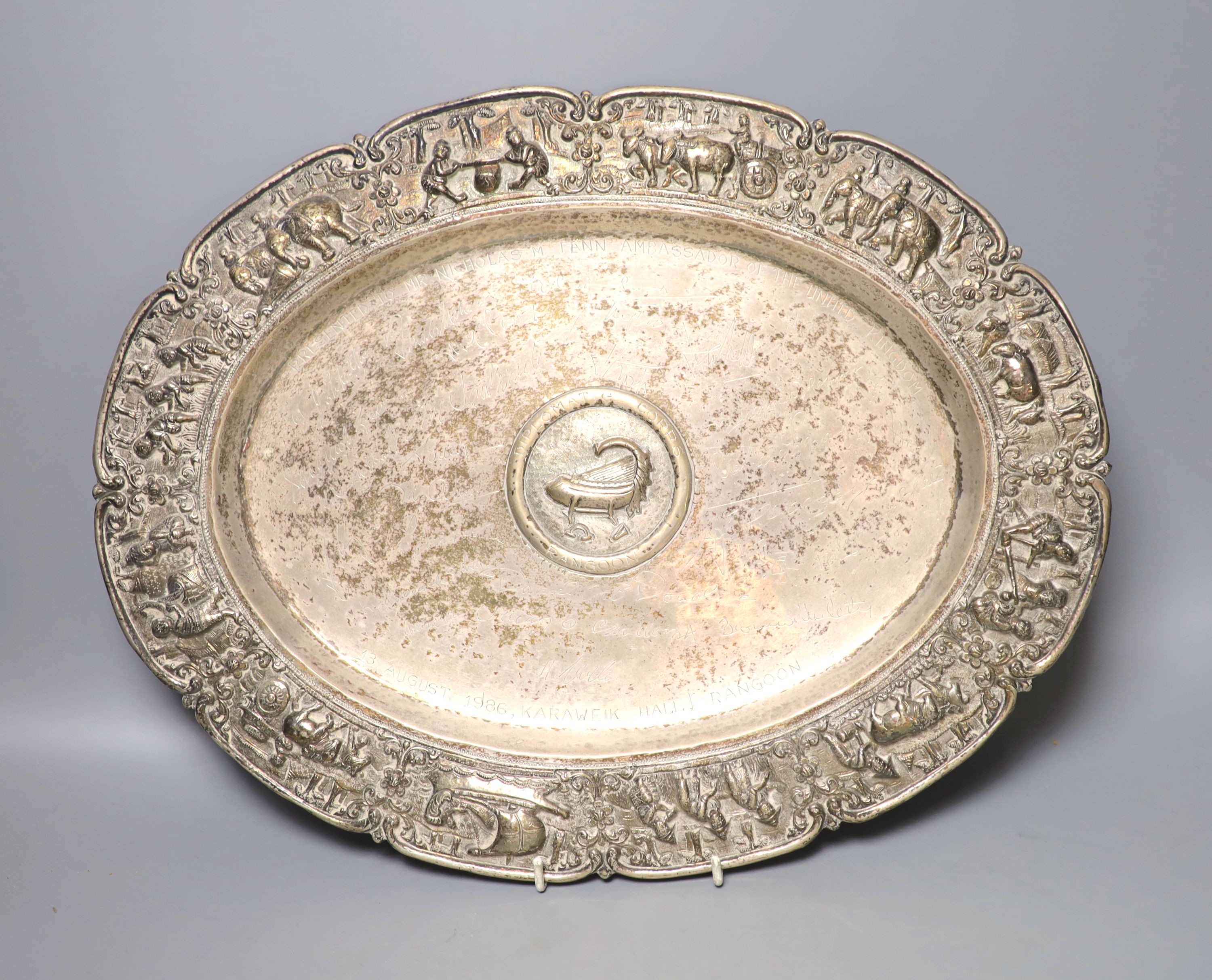 An Indian embossed white metal oval tray, with later engraved inscription and initials, 42.5cm, 27oz.